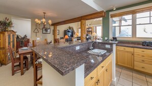 Eine geräumige Küche mit Granit-Arbeitsplatten, Holzschränken und einer großen Kochinsel.