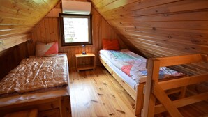 A small attic bedroom with two beds, a window, and a wooden ceiling. - Holiday Home near Lake Mausz, Kashubia (Parchowo)