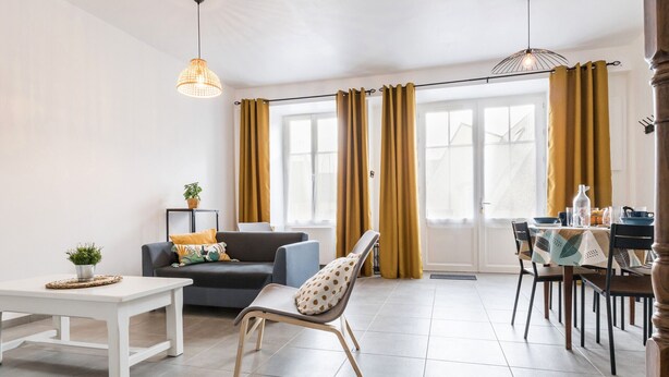 A modern living room with a sofa, a dining table with chairs, and a bench. - Renovated house with wifi, in the heart of St Mars la Jaille (Vallons-de-L'Erdre)