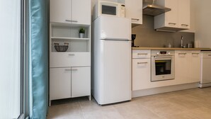 A modern kitchen with white cabinets, a built-in oven, a microwave, and a dishwasher. - Renovated house with wifi, in the heart of St Mars la Jaille (Vallons-de-L'Erdre)