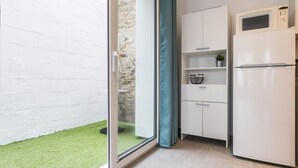 A modern kitchen with white cabinets, a white refrigerator, and a microwave. There is a small potted plant on the countertop. - Renovated house with wifi, in the heart of St Mars la Jaille (Vallons-de-L'Erdre)