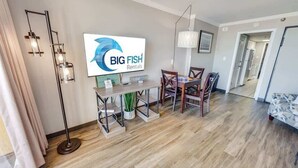 Moderni olohuone, jossa on ruokailutila, taulutelevisio ja Big Fish Rentals -vuokrauspalvelun kyltti.