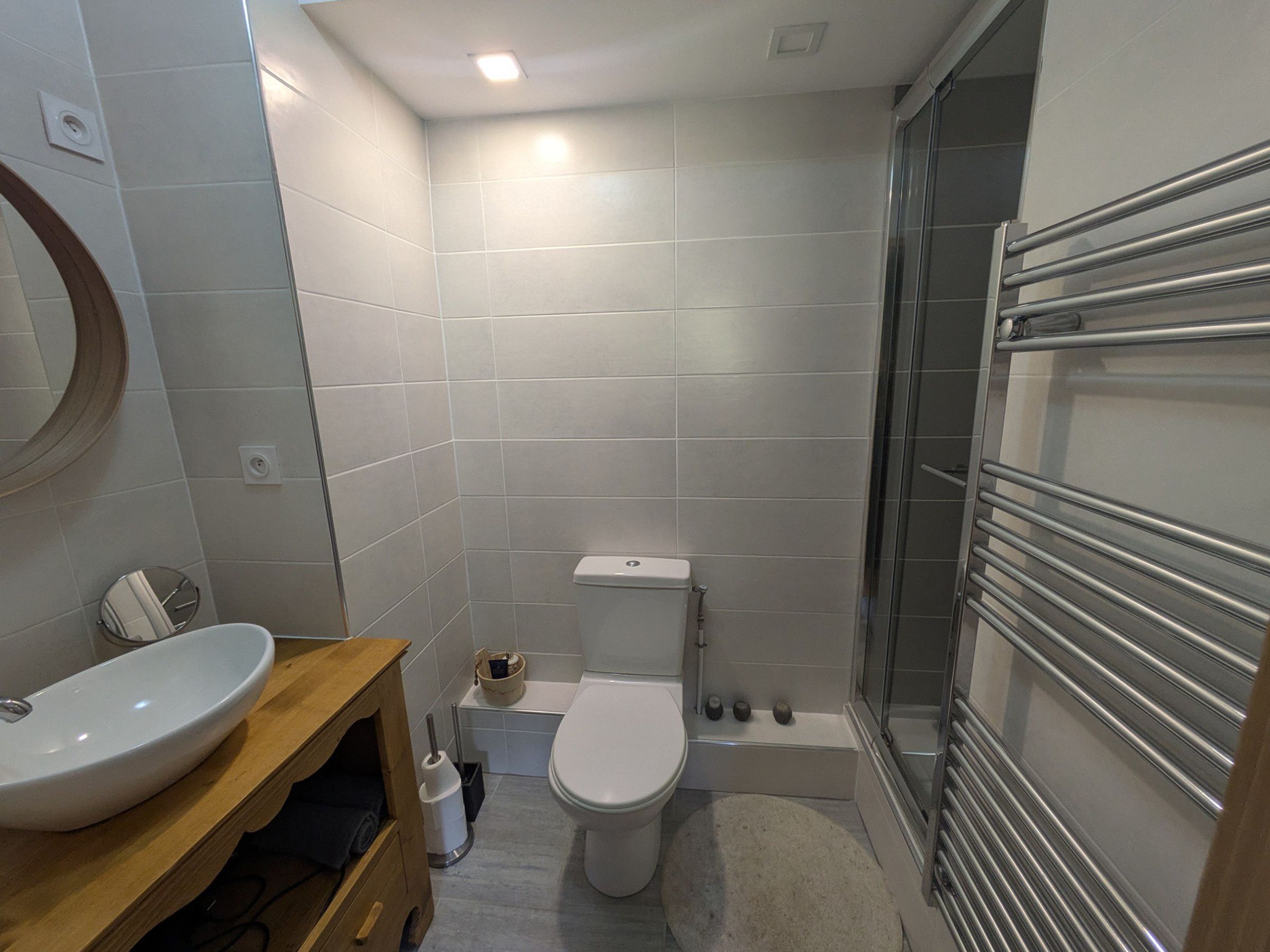 Et badeværelse med toilet, vask og bruseområde.