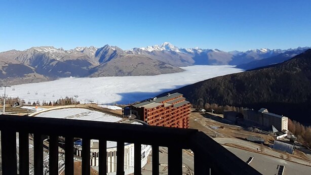 Un paysage montagneux avec une vallée et une étendue d’eau en contrebas.