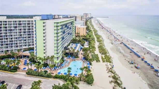 Un hôtel doté d’une piscine, d’un accès à la plage et offrant une vue sur l’océan.