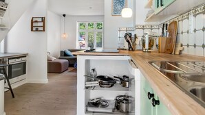 A modern kitchen with a built-in stove, wooden countertops, and a green cabinet.