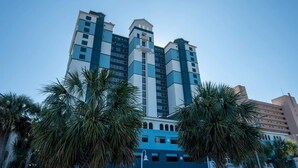 Ein mehrstöckiges Hotel mit modernem Design, das durch einen markanten, zentralen Turm und eine symmetrische Fassade gekennzeichnet ist.