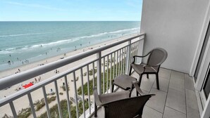 Ein Balkon mit Blick auf Strand und Meer.