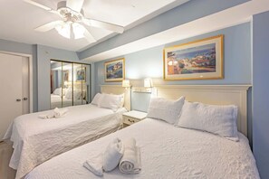 A hotel room with two beds, a ceiling fan, a large mirror, and artwork on the walls. - 3BR in Sand Dunes Resort, Oceanview, King Suite! (Myrtle Beach)