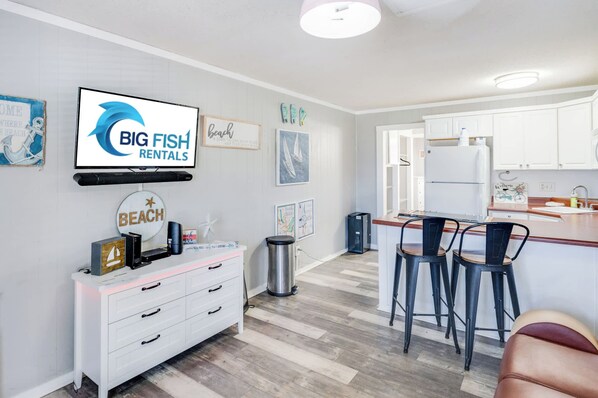 A modern kitchen with white cabinets, a built-in oven, and a stainless steel refrigerator.