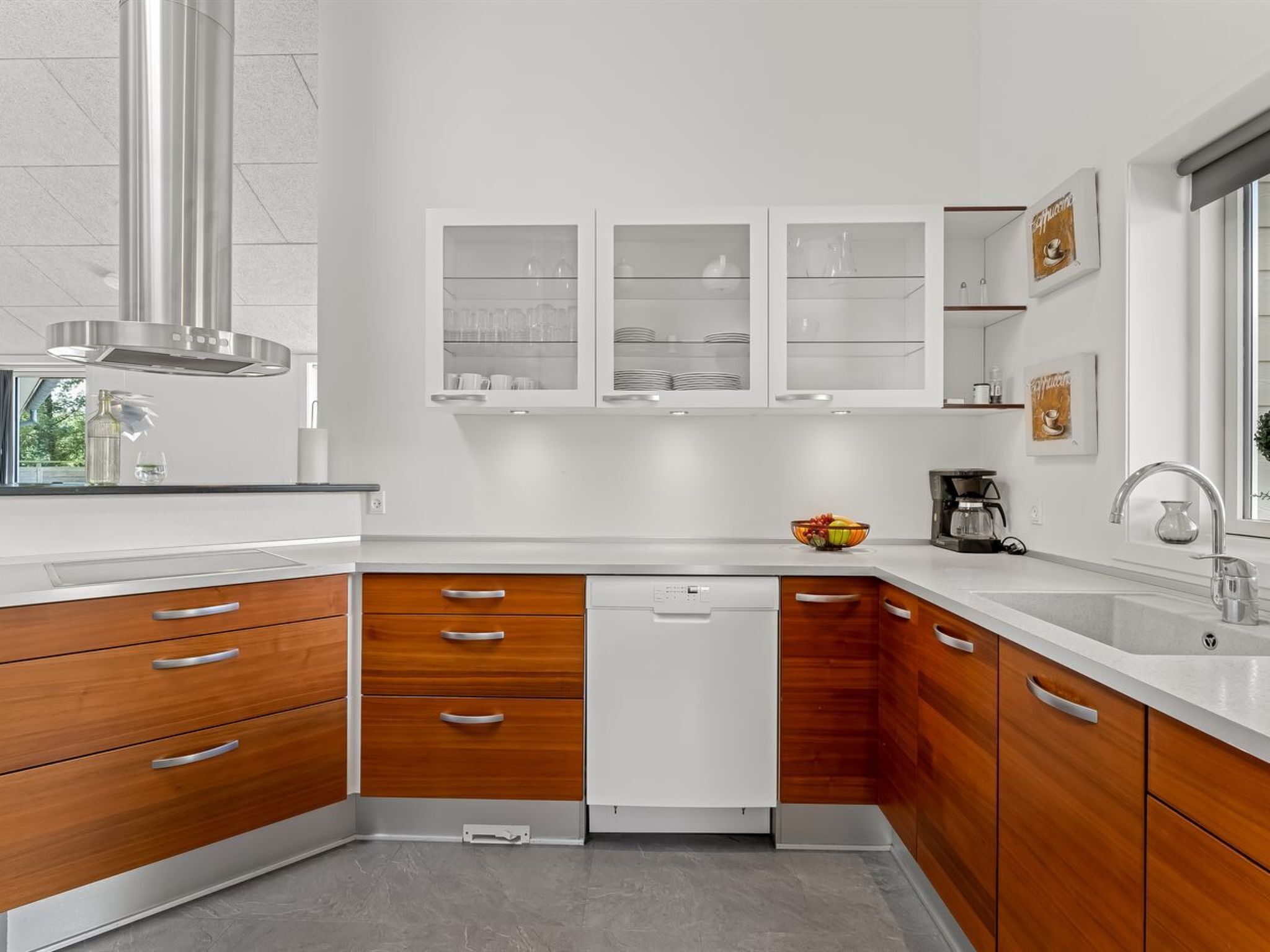 A modern kitchen with wooden cabinets, a built-in dishwasher, and a coffee maker.
