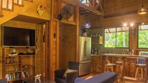 A cozy wooden cabin interior with a living area, a bar, and a kitchen. - Treehouse in the Canopy close to beach - large garden with trails - Pavones wave (Pavones)