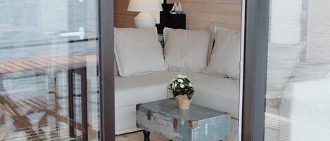 A cozy room with a sofa, a small table with a plant, and a lamp.