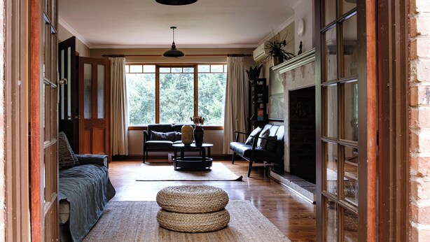 A spacious living room with a large window, a fireplace, and a cozy seating area. - The Tolpuddle Cottage (Warburton)