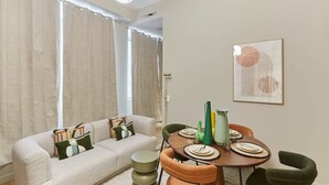 A modern living room with a sofa, dining table, and chairs.