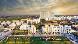 Ένα σύγχρονο ξενοδοχειακό συγκρότημα με πολλά κτίρια, μια κεντρική αυλή με χώρους παιχνιδιού και έναν μεγάλο χώρο στάθμευσης.