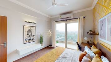 Une chambre moderne avec un lit, un ventilateur de plafond, un appareil de climatisation, une grande fenêtre avec des rideaux et une vue sur la ville.