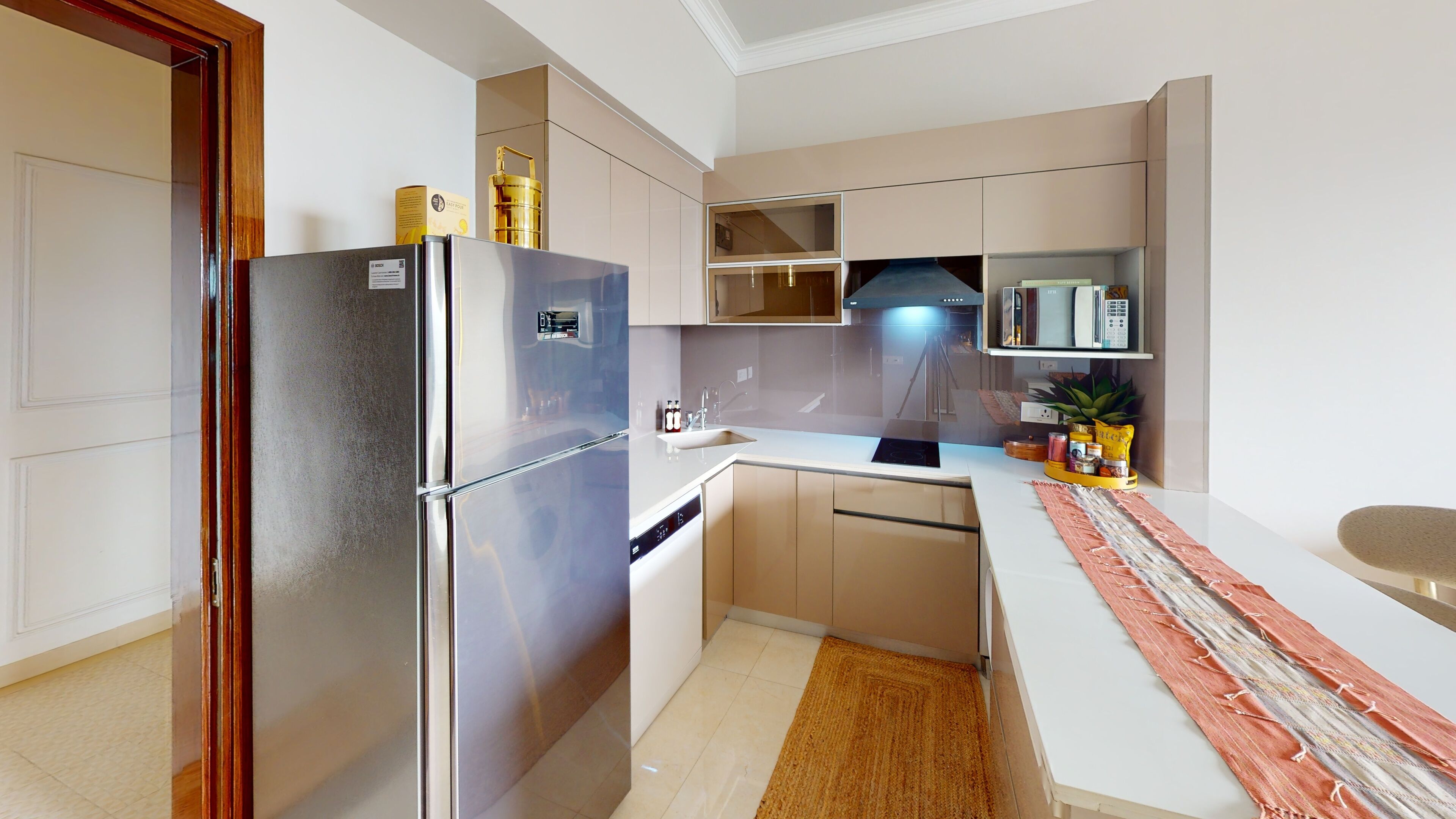 A modern kitchen with a stainless steel refrigerator, a built-in oven, and a sink.