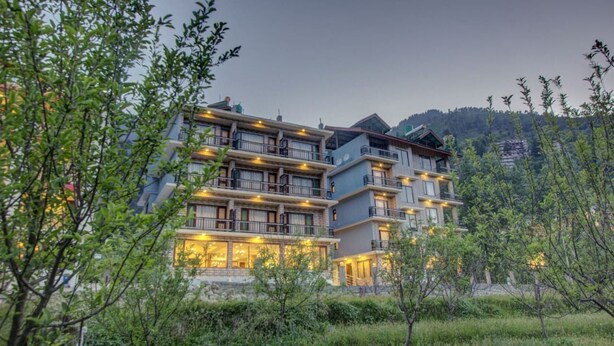 Ein mehrstöckiges Hotel mit Balkonen und einer gut beleuchteten Fassade.