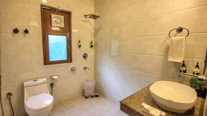 Ein Badezimmer mit Toilette, Waschbecken, Dusche und Fenster.