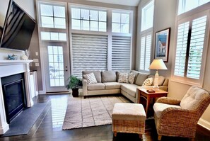A living room with a fireplace, a sofa, a chair, and a lamp.