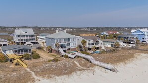 A coastal residential area with multiple two-story houses featuring balconies and a wooden boardwalk leading to the beach. - Oceanfront 8 BR Beach House with a Private Pool! Haven of Rest (Murrells Inlet)