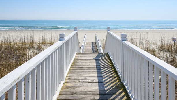A wooden boardwalk leading to a beach with white railings. - Oceanfront 8 BR Beach House with a Private Pool! Haven of Rest (Murrells Inlet)