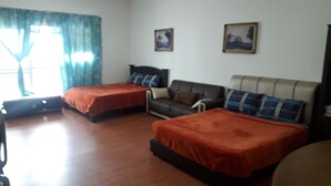 A room with two beds, a sofa, and two paintings on the wall. - Maytower Service Studio Apartment (Kuala Lumpur)