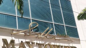 The exterior of the May Tower Hotel & Serviced Apartments with a modern glass facade and a prominent sign. - Maytower Service Studio Apartment (Kuala Lumpur)