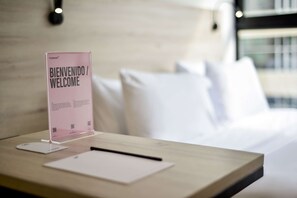 A hotel reception desk with a welcome sign, a notepad, and a pen.