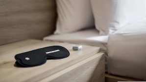 A black object with text on it, a small metallic item, and a wooden surface.