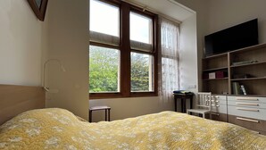 A bedroom with a bed, a window, a desk, and a bookshelf. - Small duplex "pointe du moulinet" in a listed villa (Dinard)