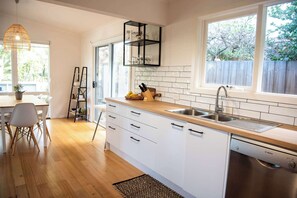 Enjoy cooking in this kitchen with dishwasher and large window offering a view of the backyard.