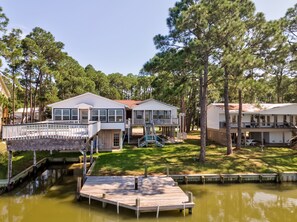 A waterfront property with two main buildings, a dock, and a small docked boat.