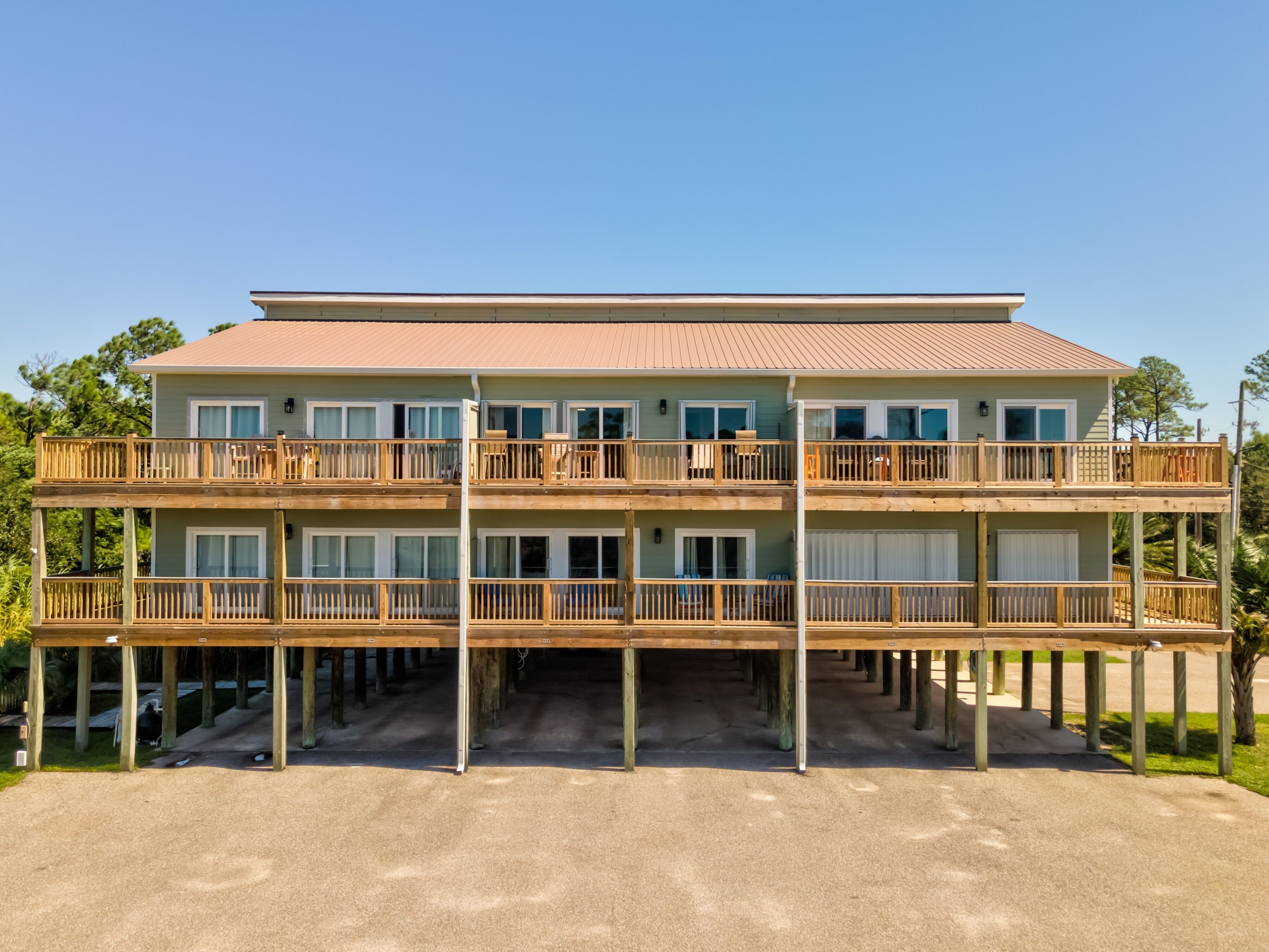 Ein mehrstöckiges Hotel mit flachem Dach, Holzbalkonen und einem Sandfußboden.