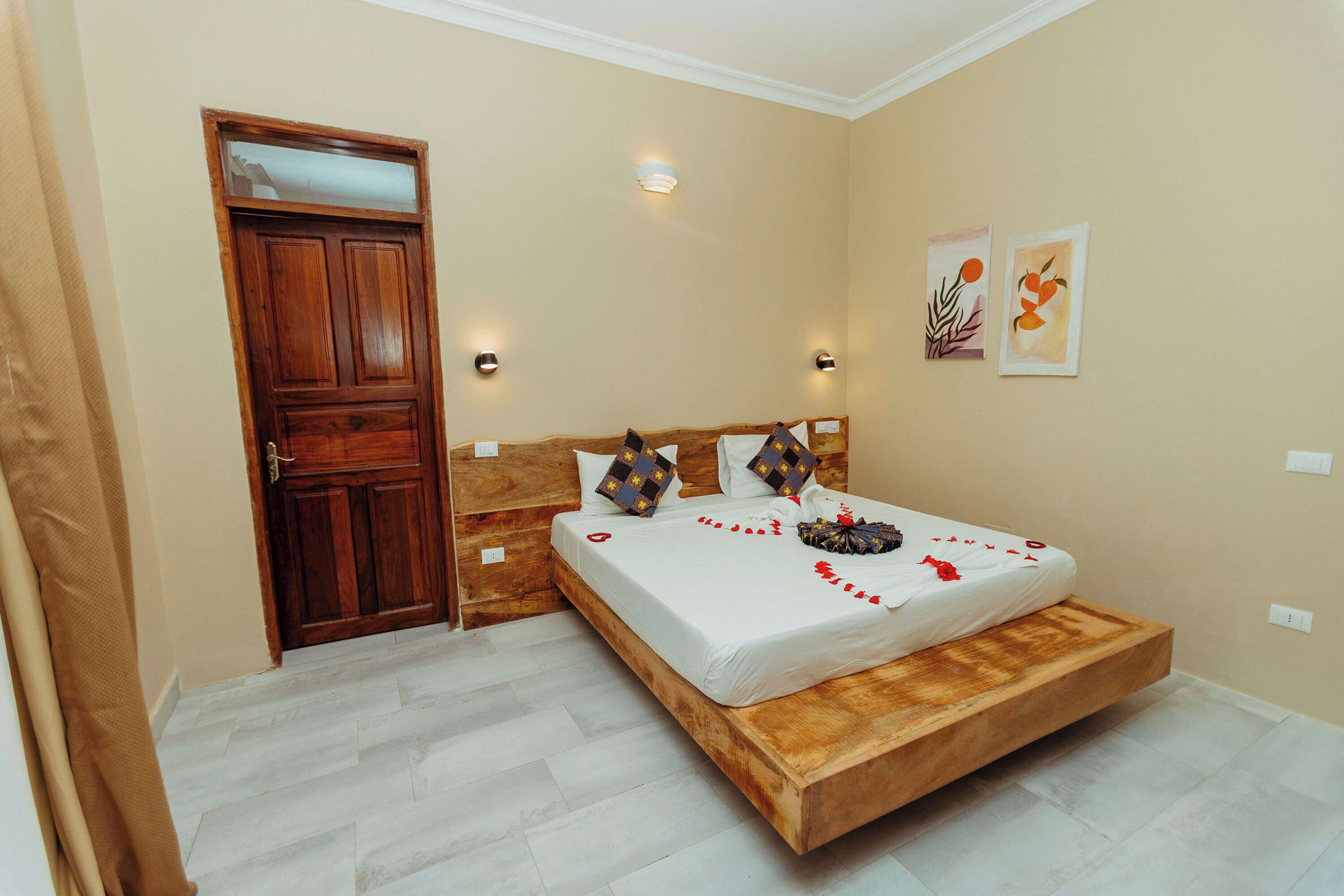 Een slaapkamer met een houten bed, een deur en twee wandlampen.