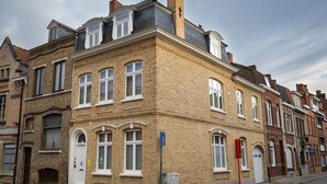 Ein historisches Gebäude mit Ziegelaußenwand, zahlreichen Fenstern und einer gepflasterten Straße.