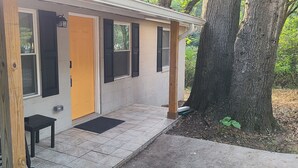 Una casa con porche, una banca y una puerta.
