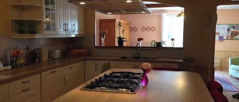 A kitchen with a central island, wooden cabinets, and a stainless steel range hood.