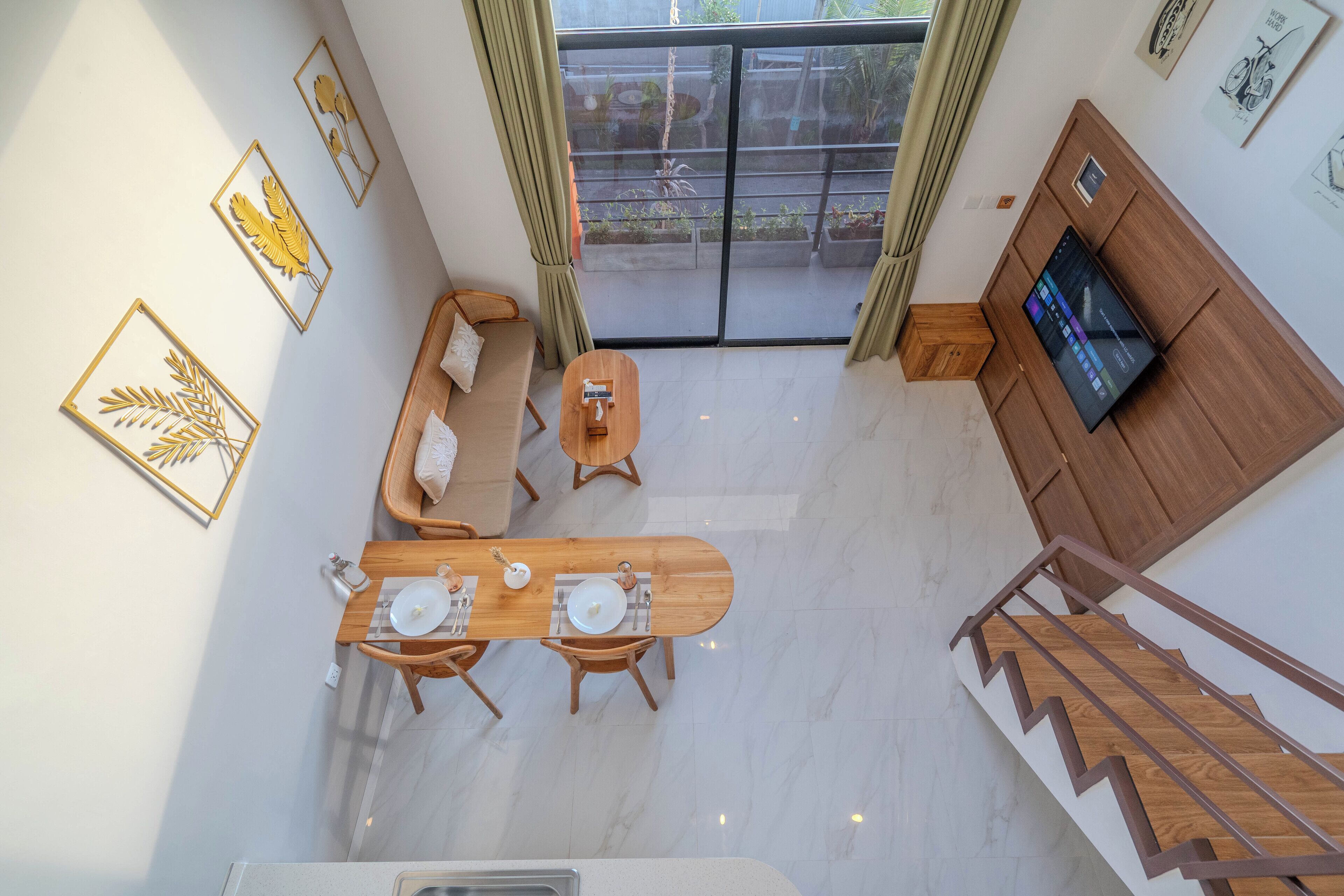 A modern living room with a wooden dining table, sofa, and TV.