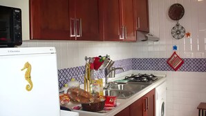A kitchen with wooden cabinets, a white refrigerator, a microwave, a sink, and a stove. - Cozy apartment with breathtaking views in Positano. CIN IT065100C2D8D7L43H (Positano)