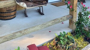 A rustic wooden porch with a welcome sign, a bench, and a sled. - Charming farmhouse in delightful Brantley with AC (Brantley)