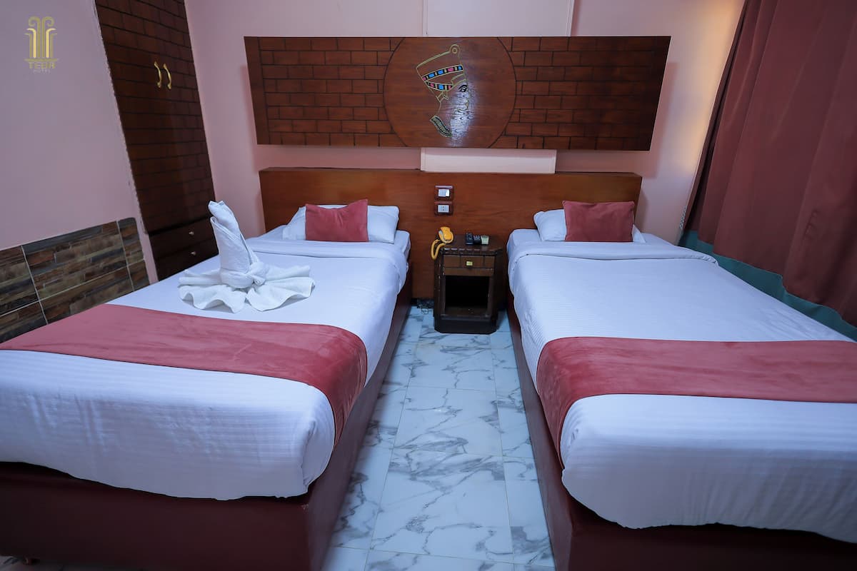 A hotel room with two beds, marble flooring, a wooden headboard, and a wall-mounted artwork.
