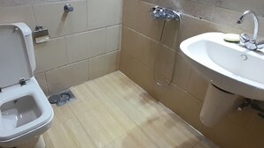 Une petite salle de bain avec des toilettes, un lavabo et une douche.