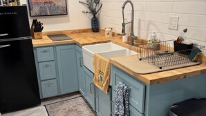 A modern kitchen with a wooden countertop, a sink, and a black refrigerator. - Cozy Private Basement in Mid-Town Lincoln (Lincoln)