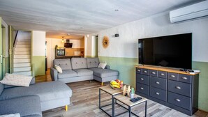 A living room with a grey sofa, a coffee table, a TV, and a cabinet with drawers. - Villa Du Soleil by Villa Plus (Laroque-des-Albères)