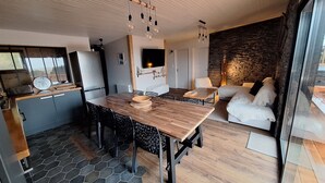 Una cocina moderna con una mesa y sillas de madera, un horno empotrado y un salpicadero de piedra.