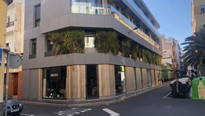 Un edificio moderno con negozi al piano terra e unità residenziali o uffici ai piani superiori.