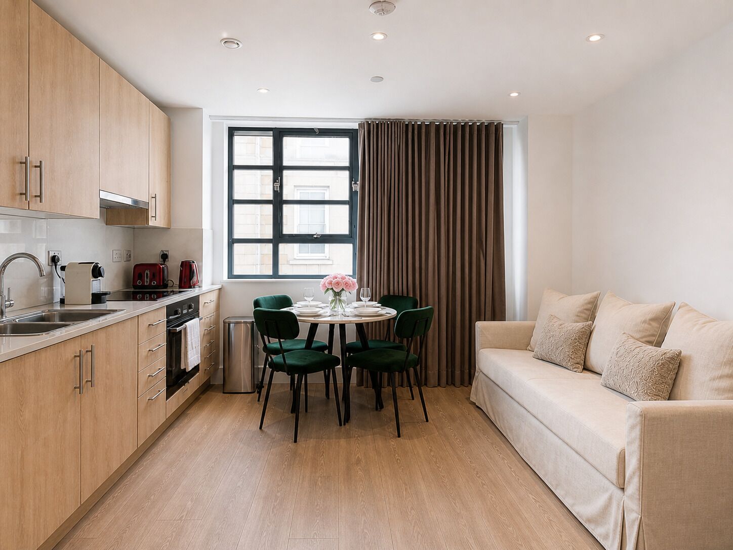 Eine moderne Küche mit Holzausbau, einem Esstisch mit Stühlen und einer Couch.