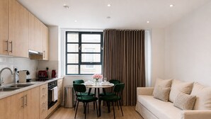 Una cocina moderna con armarios de madera, una mesa de comedor con sillas y un sofá.